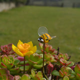 Gros plan d'une abeille en verre de Murano à côté d'une jonquille en verre de Murano