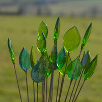 Une vingtaine de feuilles en verre de murano sur fond de campagne