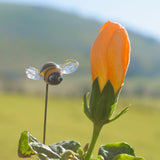 Gros plan d'une abeille en verre de Murano à côté d'une fleur